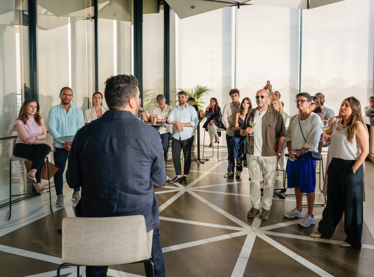 Personas interesadas en inversión inmobiliaria durante una presentación de BECCA